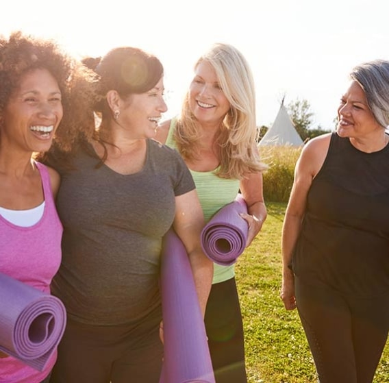 Group of women going to a Yoga class at the park.